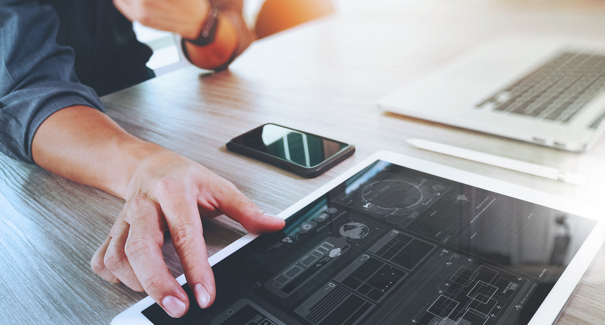 Ein Mann sitzt vor Laptop und Tablet. Bild: ©everythingpossible - stock.adobe.com