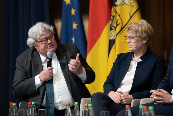 Reinhard Bütikhofer in der Diskussion, Prof. Dr. Veronika Grimm hört ihm zu.