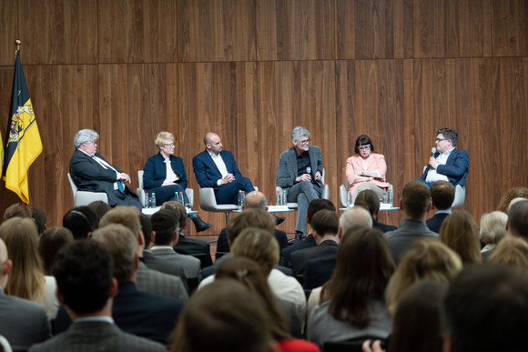 Eckart von Klaeden beantwortet eine Frage des Moderators, die weiteren Panelisten hören zu.