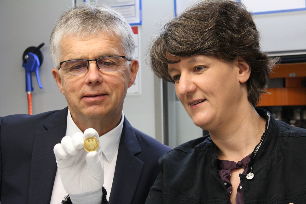 Staatssekretärin Gisela Splett und Münzleiter Peter Huber kurz nach der Anprägung der 100-Euro-Goldmünze „Luthergedenkstätten Eisleben und Wittenberg“ aus der Serie UNESCO Welterbe.