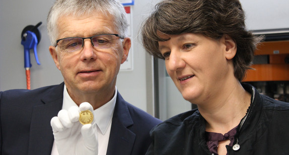 Staatssekretärin Gisela Splett und Münzleiter Peter Huber kurz nach der Anprägung der 100-Euro-Goldmünze „Luthergedenkstätten Eisleben und Wittenberg“ aus der Serie UNESCO Welterbe.