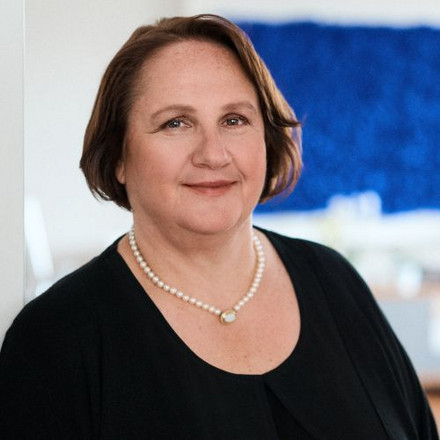 Ein Bild von Ministerin Schopper in ihrem Büro. Sie lehnt sich an den Türrahmen.