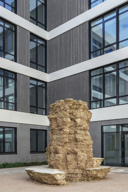 Hochbau Neues Büro- und Laborgebäude für die LUBW Naturstein-Skulptur im Innenhof des neuen Büro- und Laborgebäudes der Landesanstalt für Umwelt Baden-Württemberg (LUBW) in Karlsruhe, umgeben von moderner Glas- und Holzfassade.