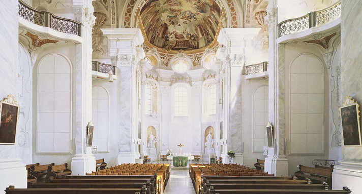 Blick in die barocke Jesuitenkirche Ellwangen mit heller, reich verzierter Innenausstattung.