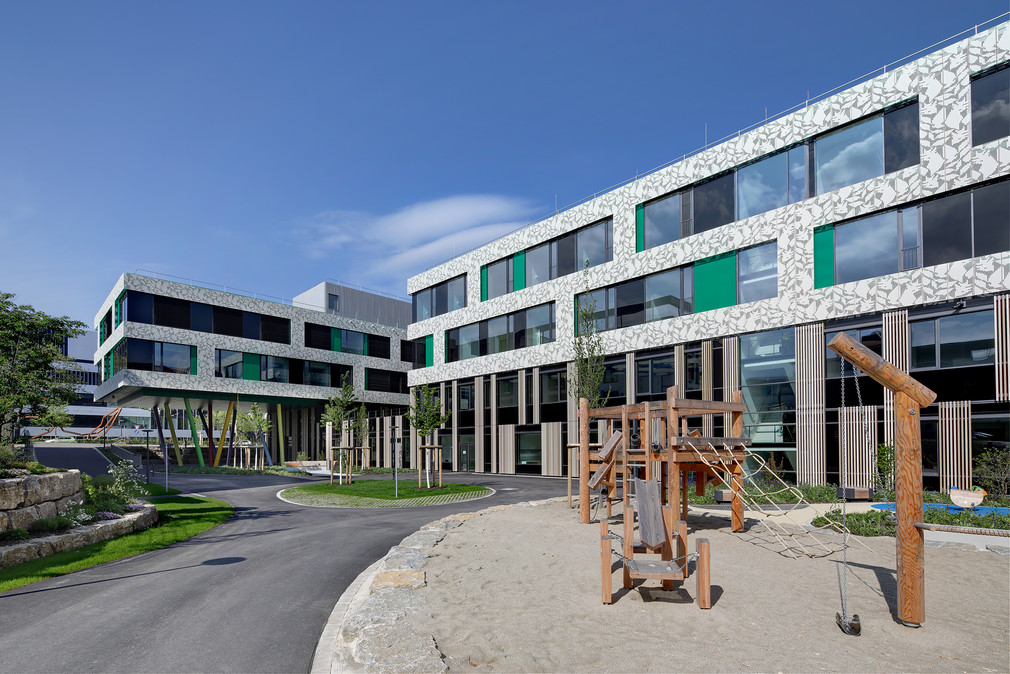 Neues Zentrum für Kinder- und Jugendmedizin in Freiburg, Blick in den Innenhof der Klinik, hier ist ein Spielplatz zu sehen und ein Teil vom Gebäude im Hintergrund