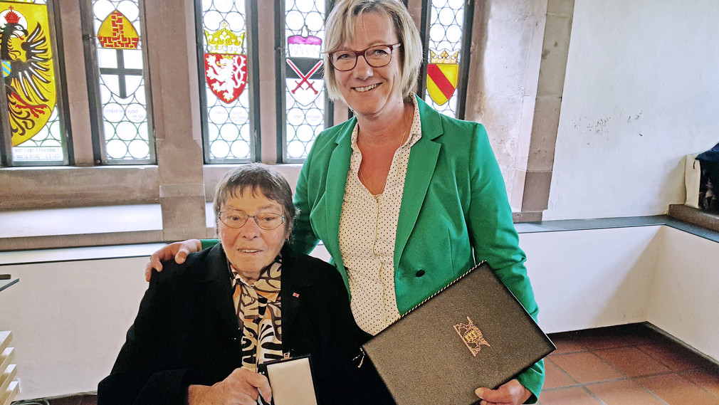 Finanzministerin Edith Sitzmann ehrt Maria Steinle für ihr humanitäres Engagement mit dem Verdienstkreuz am Bande.