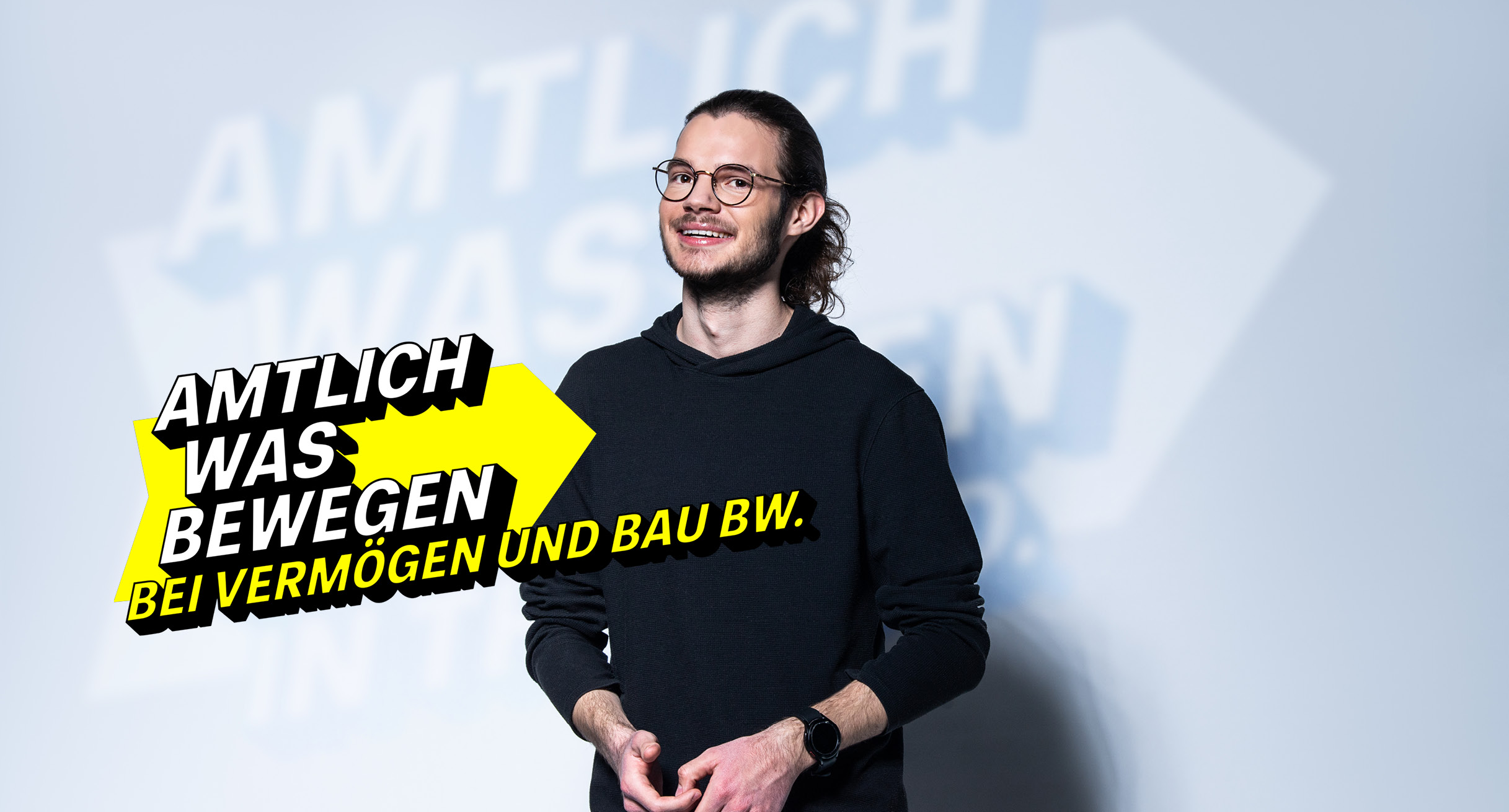 Junger, moderner Mann im schwarzen Pullover steht für die Steuerverwaltung BW.