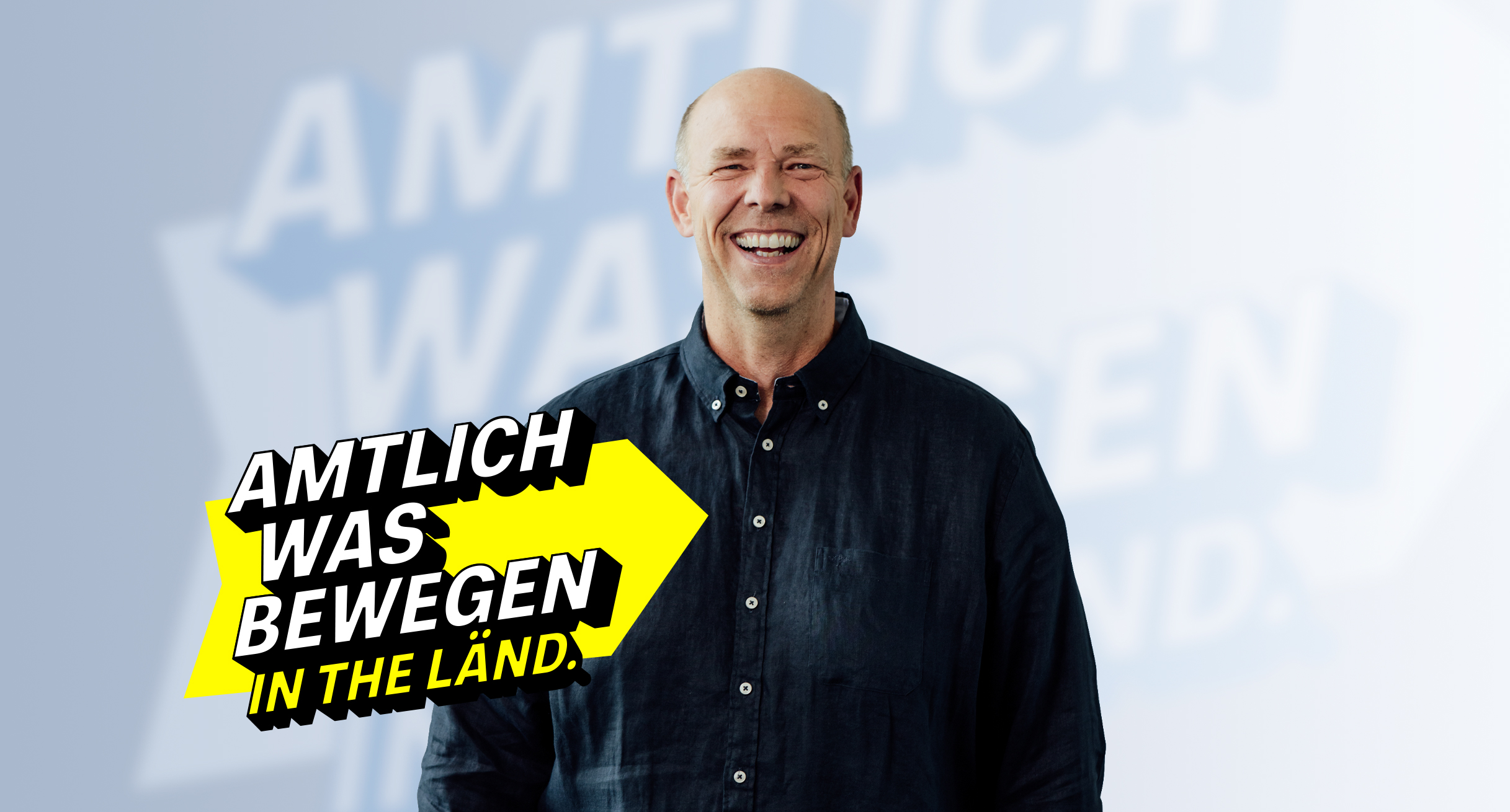 Lächelnder Mann im dunklen Hemd im Vordergrund, steht für Engagement im Land Baden-Württemberg.